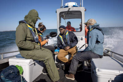 The Common podcast producer Katelyn Harrop records host Darryl C. Murphy as they travel across Boston Harbor. (Robin Lubbock/WBUR)