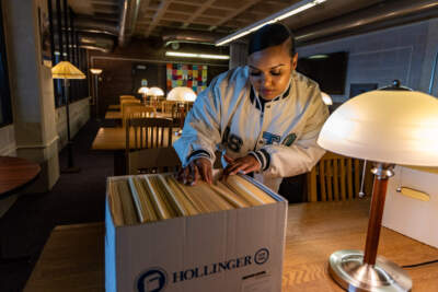 Ebony Gill sifts through the archive of local Boston area music fanzines at the Healey Library at UMass Boston. (Jesse Costa/WBUR)