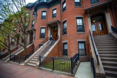 A resident of an affordable housing unit on Massachusetts Avenue walks up the stairs to enter her apartment, one of the buildings managed by the Tenants’ Development Corp. (Jesse Costa/WBUR)