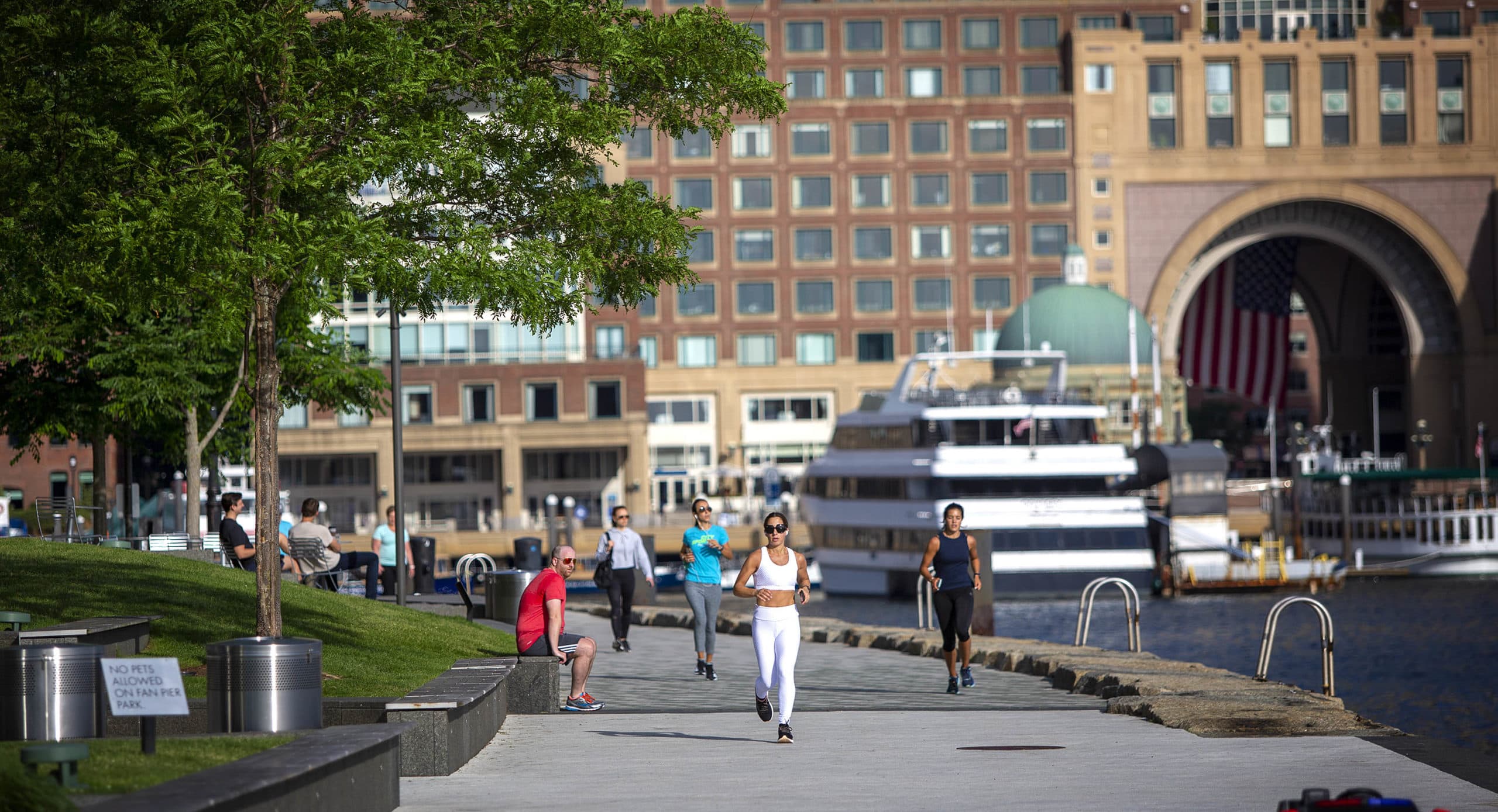 Joggers take advantage of a recent warm day as they run along the Harborwalk at Fan Pier. (Robin Lubbock/WBUR)