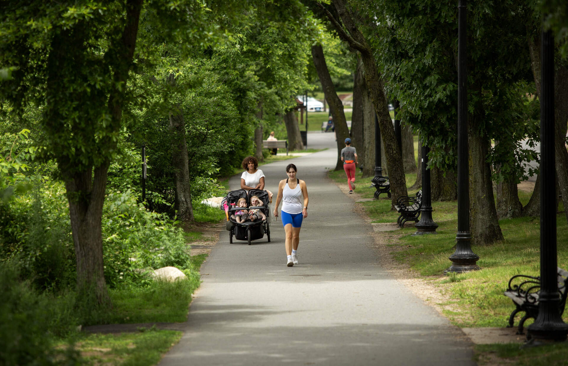 People walk along a shady footpath near Jamaica Pond. (Robin Lubbock/WBUR)