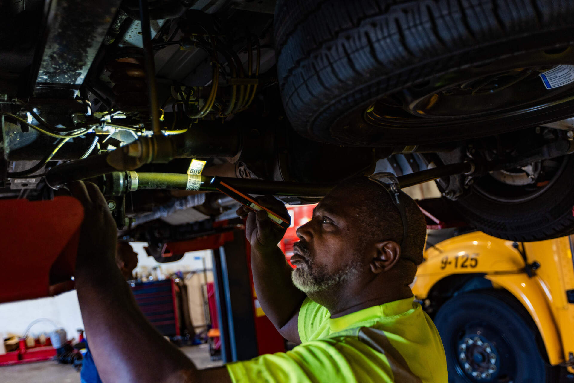 Jim Hicks does a complete check on a newly purchased bus to make sure everything is in working order before putting it out to service at the Worcester Public School bus yard. (Jesse Costa/WBUR)