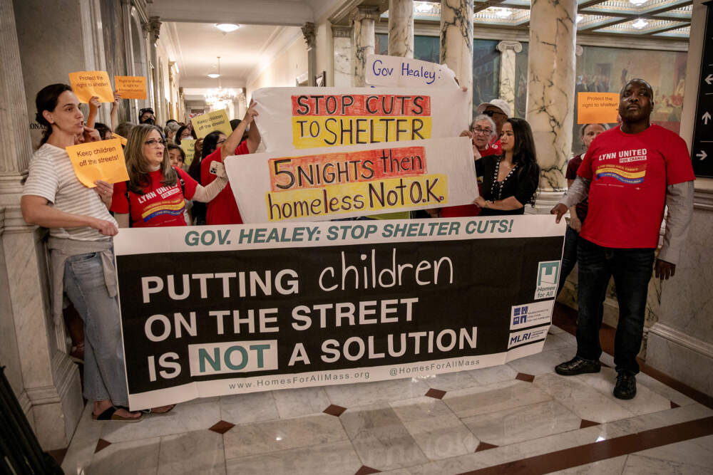 Protesters outside the Executive Office at the Massachusetts State House call on Gov. Maura Healey to reconsider new restrictions to the family shelter system. (Robin Lubbock/WBUR)