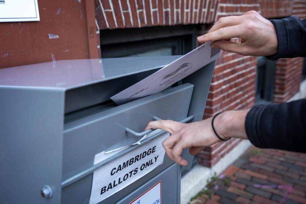 A voter places his ballot into a Cambridge drop box in 2020. (Robin Lubbock/WBUR)