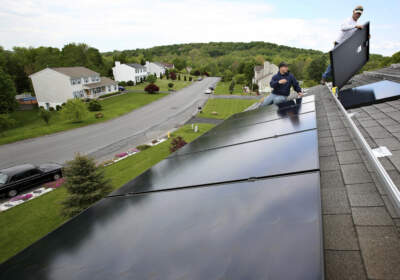 Marco DelTreste, left, and Arsenio Patricio, of Mercury Solar Systems, install panels on the roof of a home in Newburgh, N.Y. (Craig Ruttle/AP)