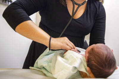 A pediatrician examines a newborn baby. (Amr Alfiky/AP Photo)