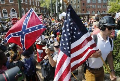 White nationalist demonstrators walk into Lee park surrounded by counter demonstrators in Charlottesville, Va., Saturday, Aug. 12, 2017. (Steve Helber/AP)