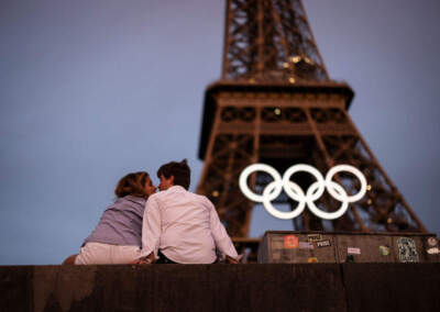 A couple kiss under the Eiffel Tower as the Olympic Rings are displayed ahead of the Paris 2024 Olympic Games on June 27 in Paris. (Ryan Pierse/Getty Images)