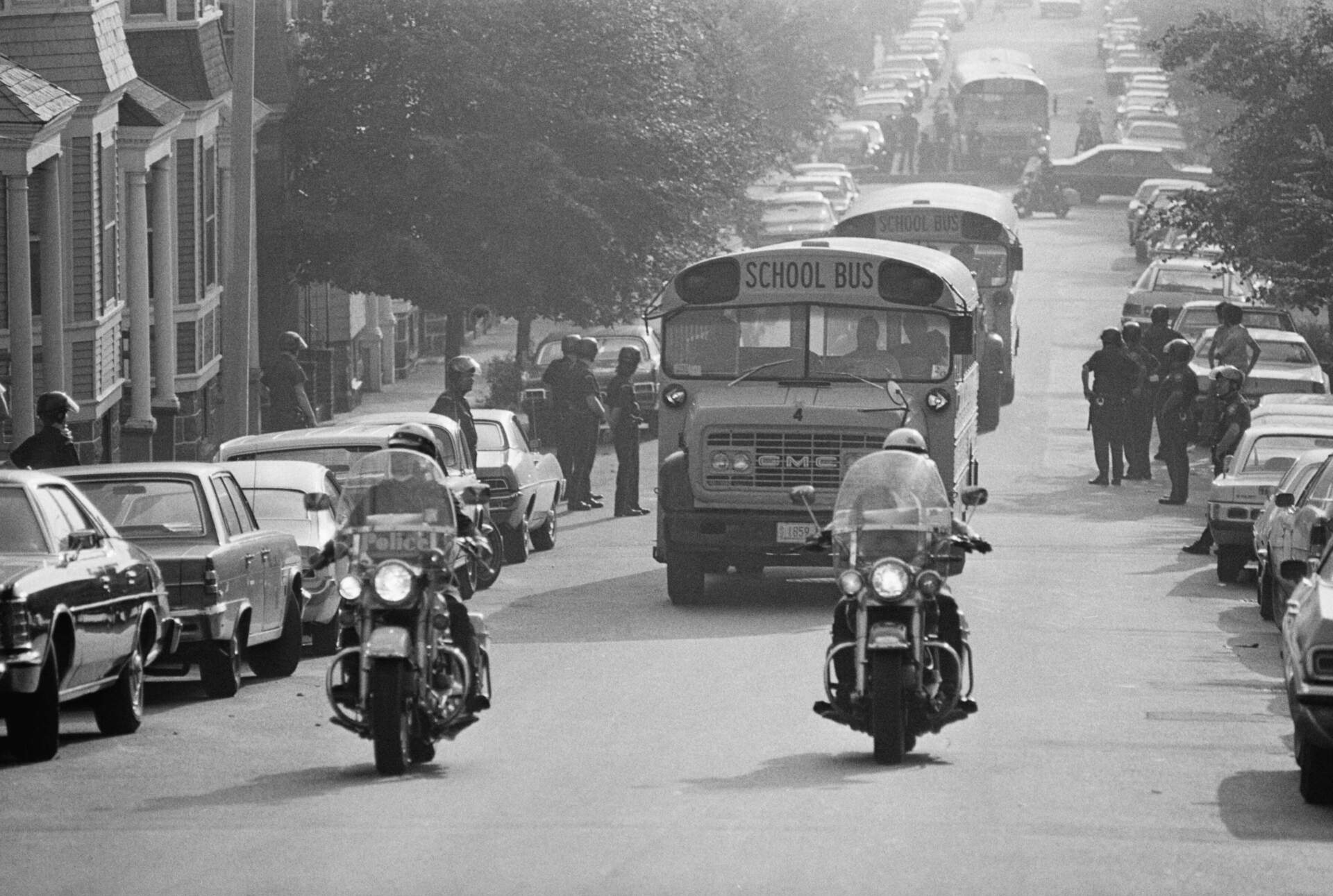 Helmeted police protect route as school buses carrying students to South Boston High School. (Getty images)