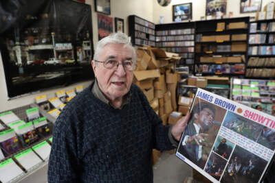 Fred LeBlanc, known as Skippy White since 1961, holds up a James Brown record inside his store in Dorchester on Dec. 22, 2019. (Pat Greenhouse/The Boston Globe via Getty Images)